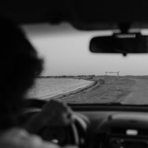Black and white view from a car driving through a deserted landscape, capturing a serene journey.