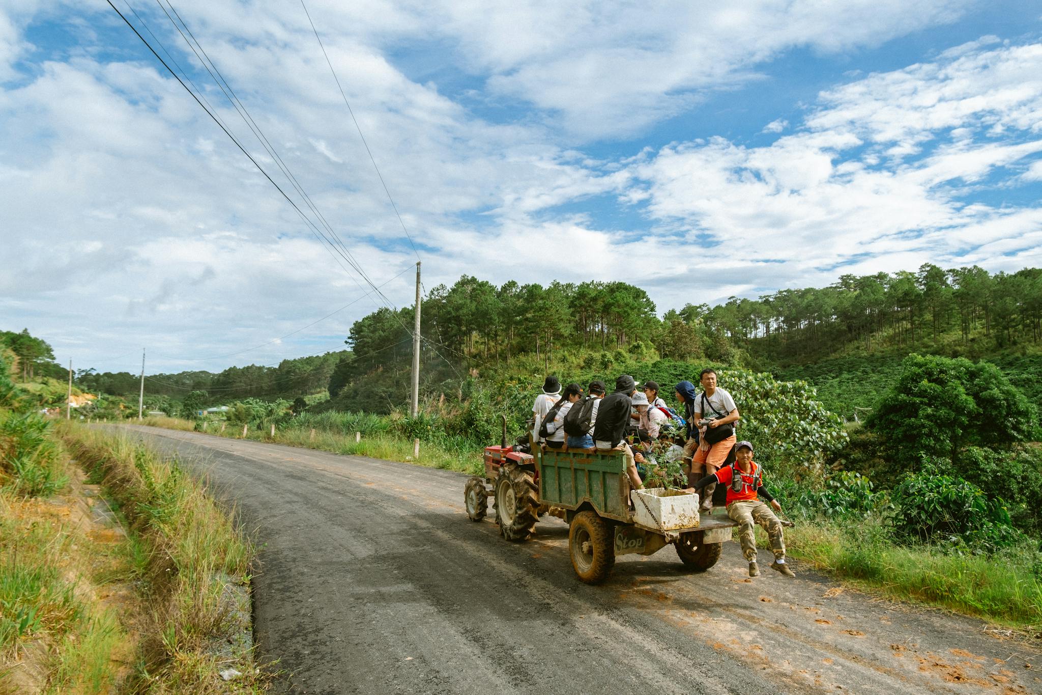 Group of people enjoying a tractor ride through the scenic countryside of Bảo Lộc, Vietnam.